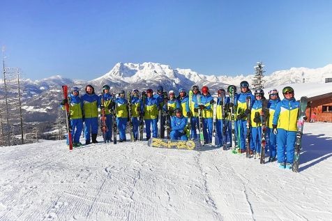 Gruppenbild von Skischülern. Im Hintergrund sieht man das Tennengebirge.