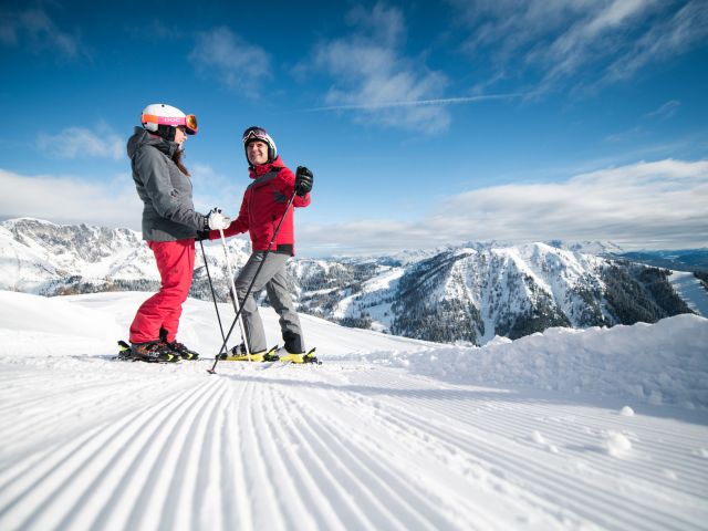 2 Skifahrer unterhalten sich auf der Piste.