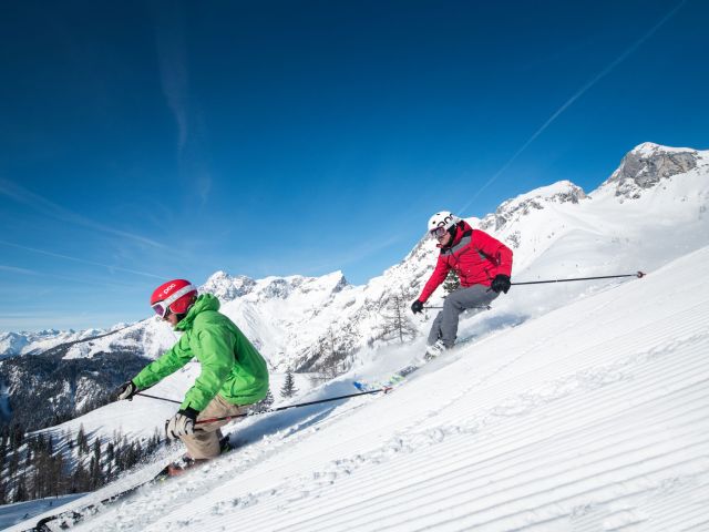 Lateral close up of 2 skiers on the piste.